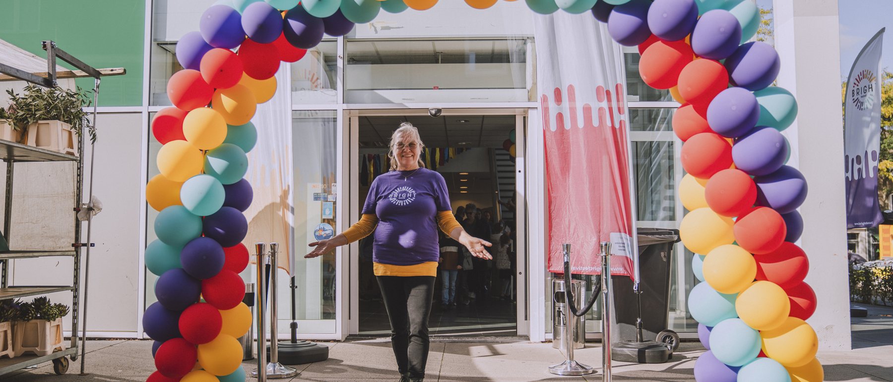 Bezoekers lopen onder een ballonboog naar binnen