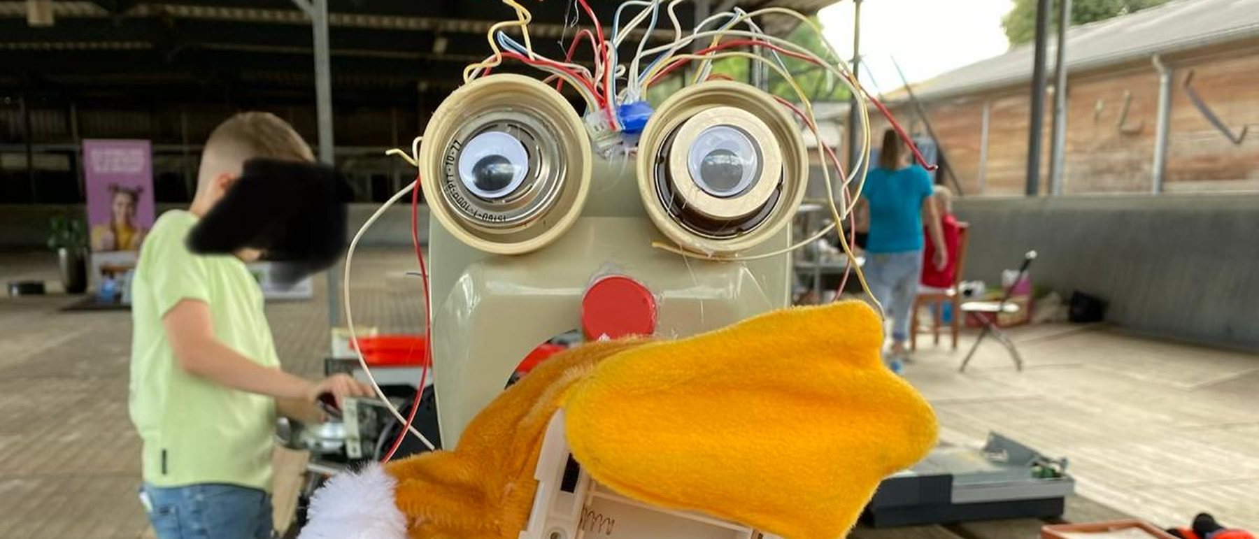 Een robot gebouwd uit een oude broodrooster, met draadjes als haar