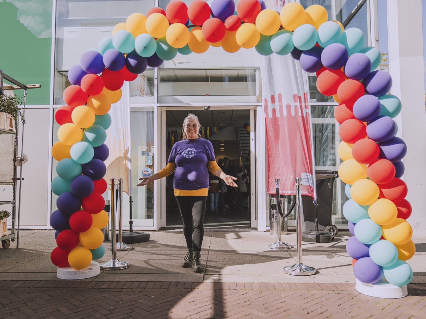 Bezoekers lopen onder een ballonboog naar binnen op de publieksdag
